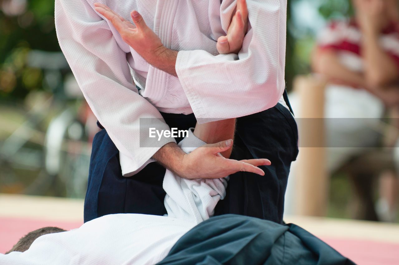 Midsection of men practicing karate in studio