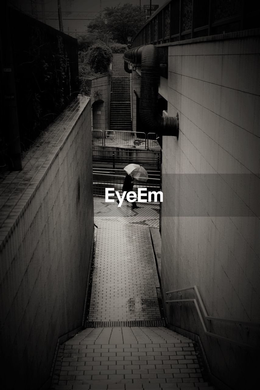 High angle view of man walking on footpath during rainy season