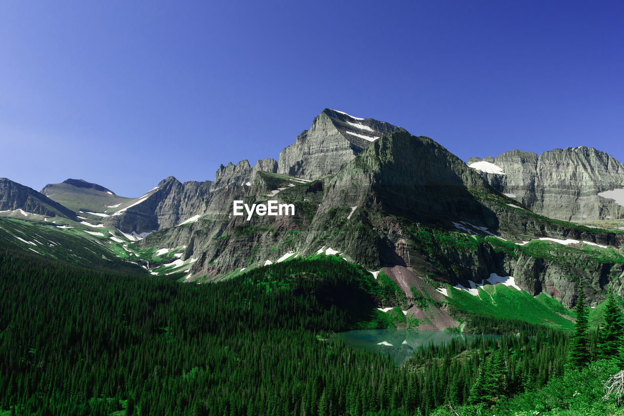 Scenic view of mountains against blue sky