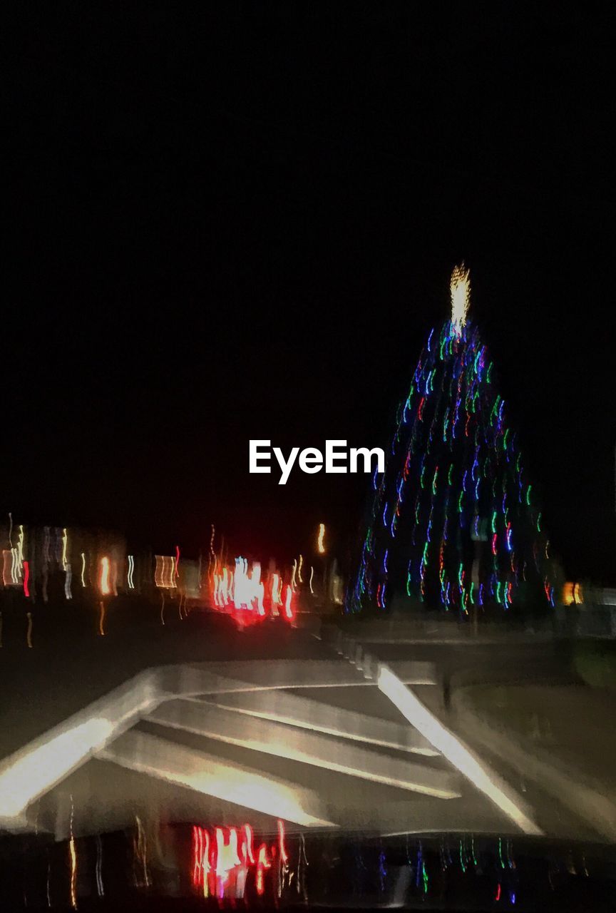 ILLUMINATED CHRISTMAS TREE AGAINST SKY