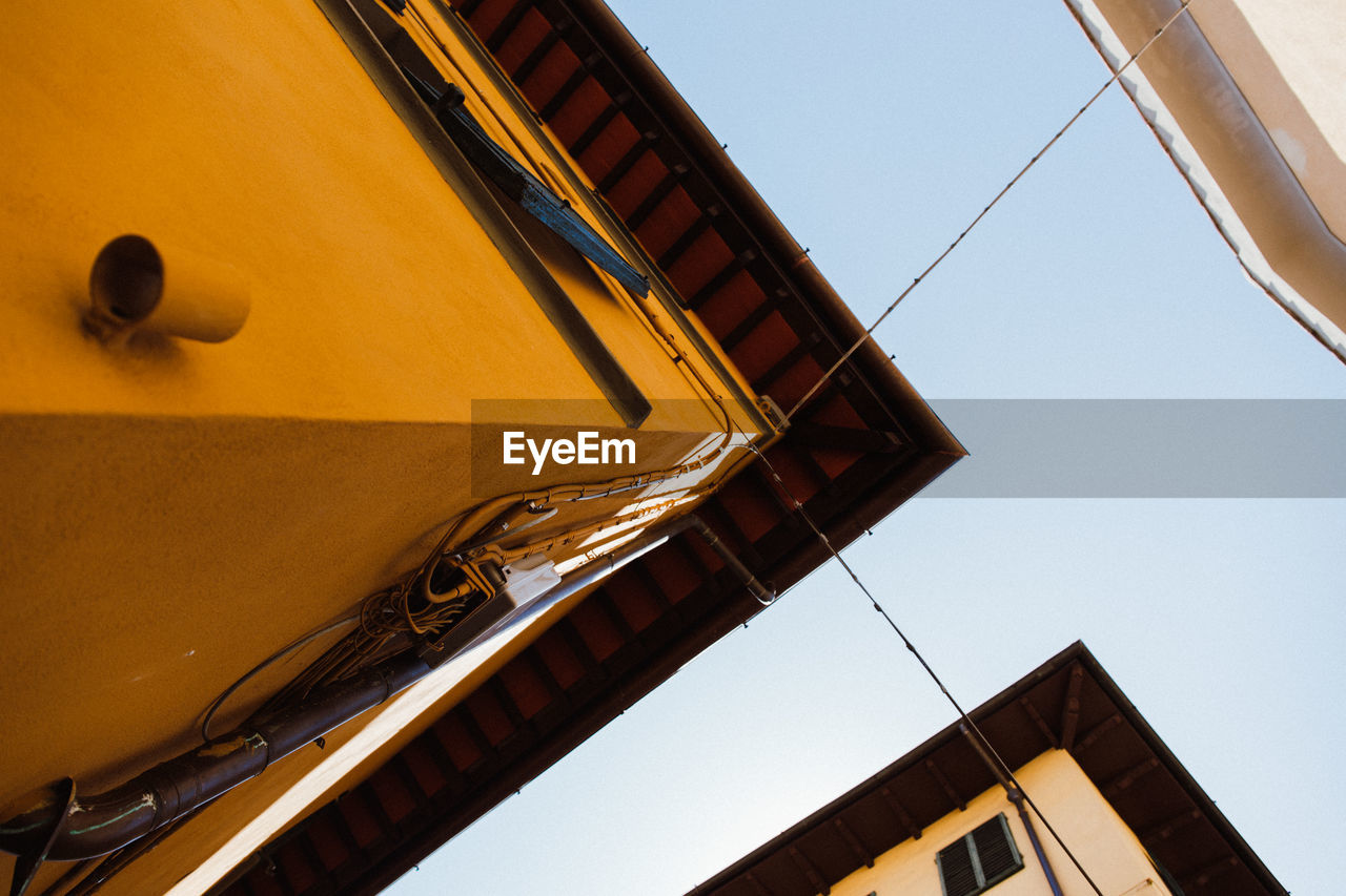 Directly below shot of yellow building against clear sky