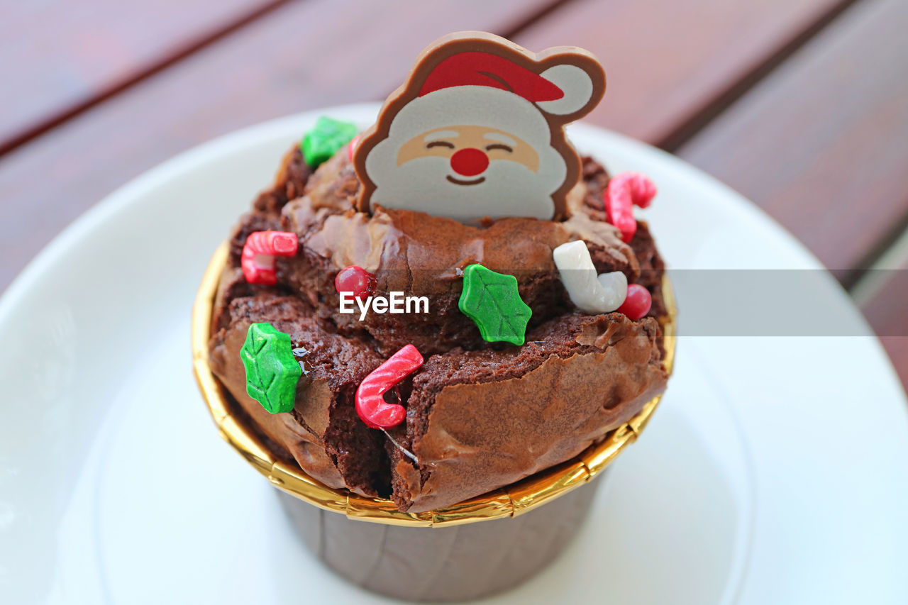 Closeup of chocolate cupcake topped with santa choco and christmas sprinkles