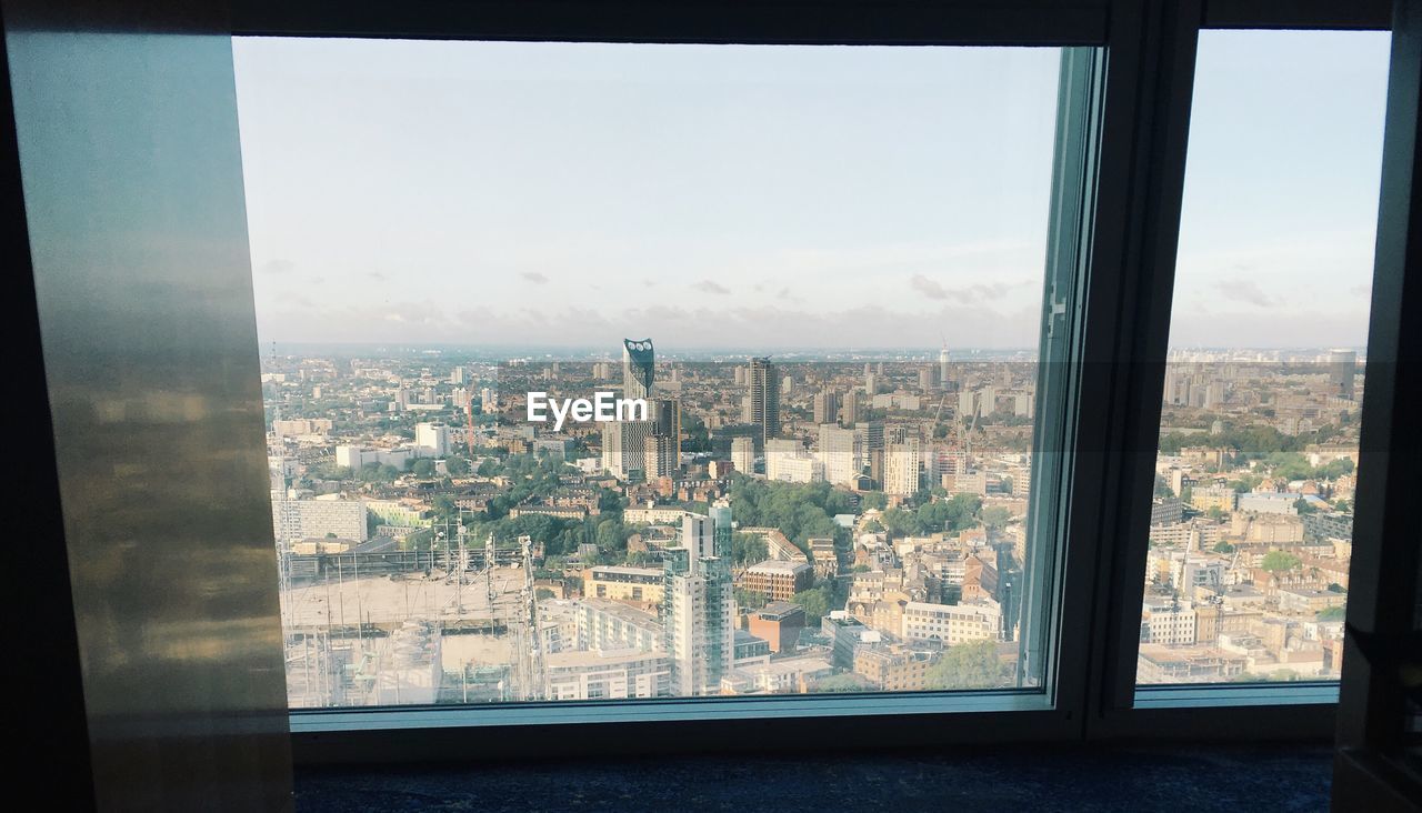 VIEW OF CITYSCAPE THROUGH MODERN WINDOW