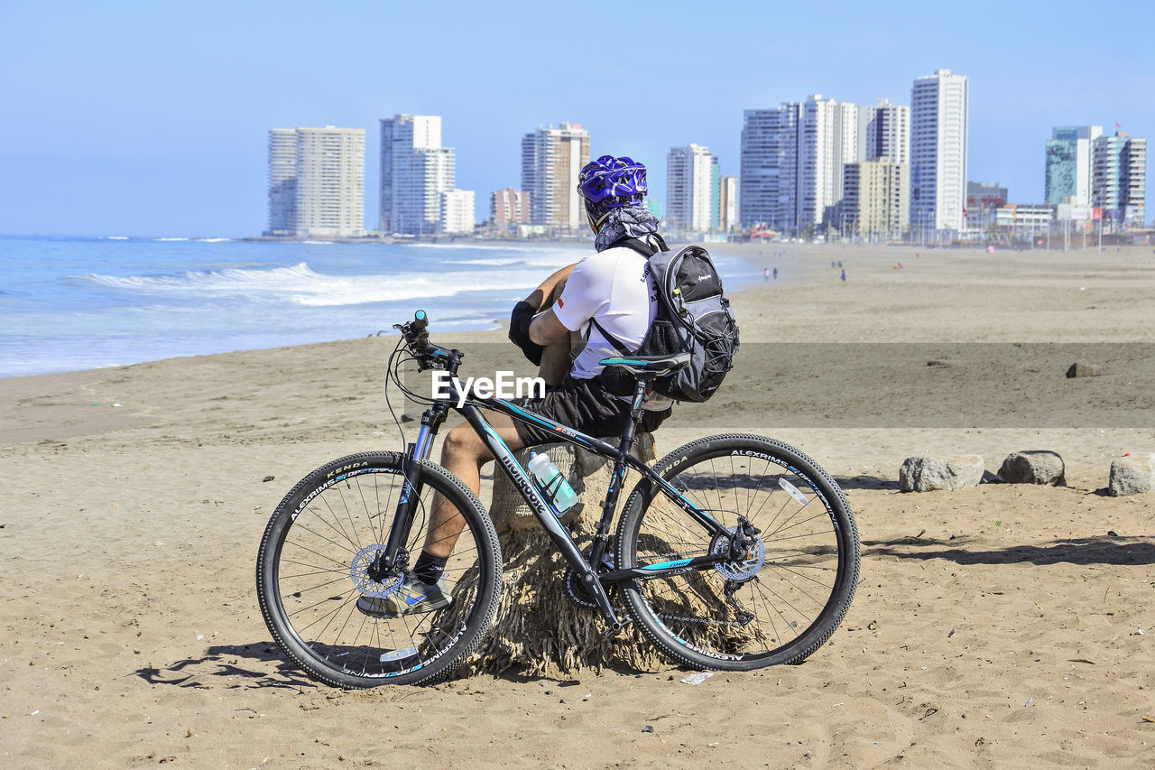 BICYCLES ON BEACH AGAINST SKY