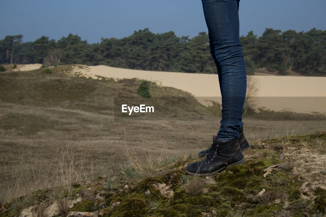 Low section of woman standing on landscape