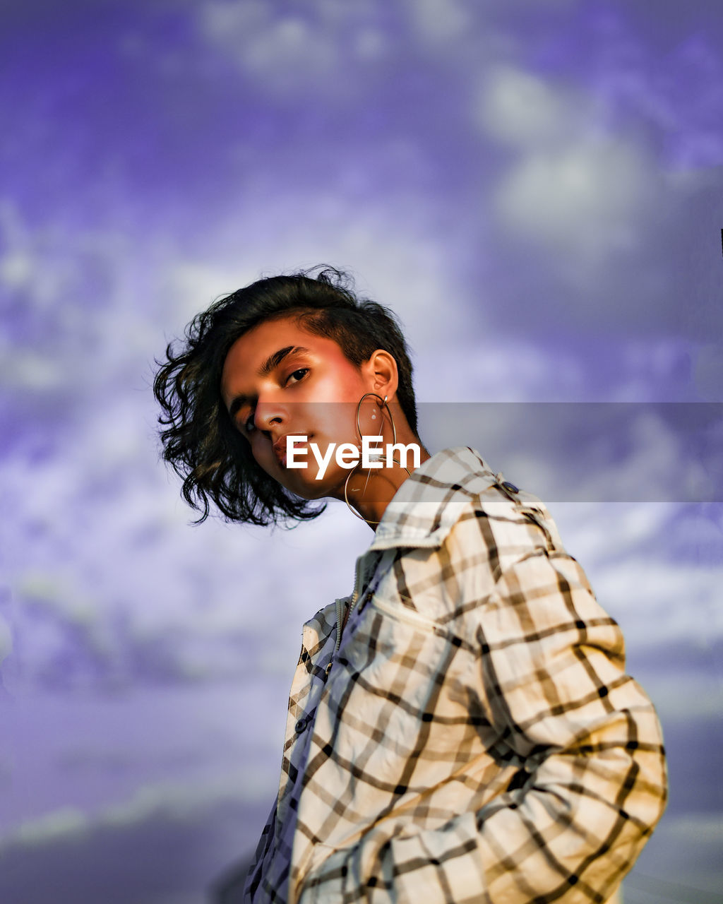 Portrait of smiling young woman against sky