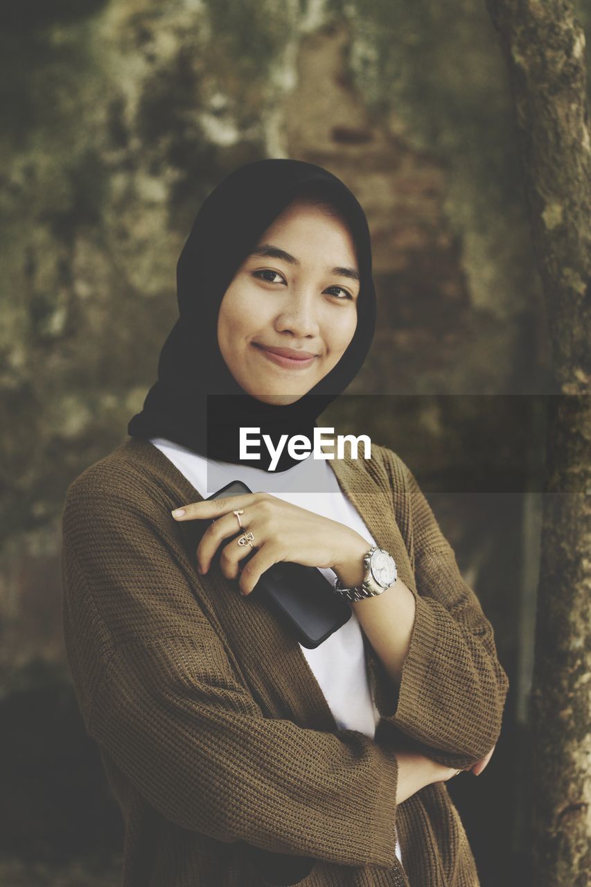 Portrait of smiling young woman standing outdoors