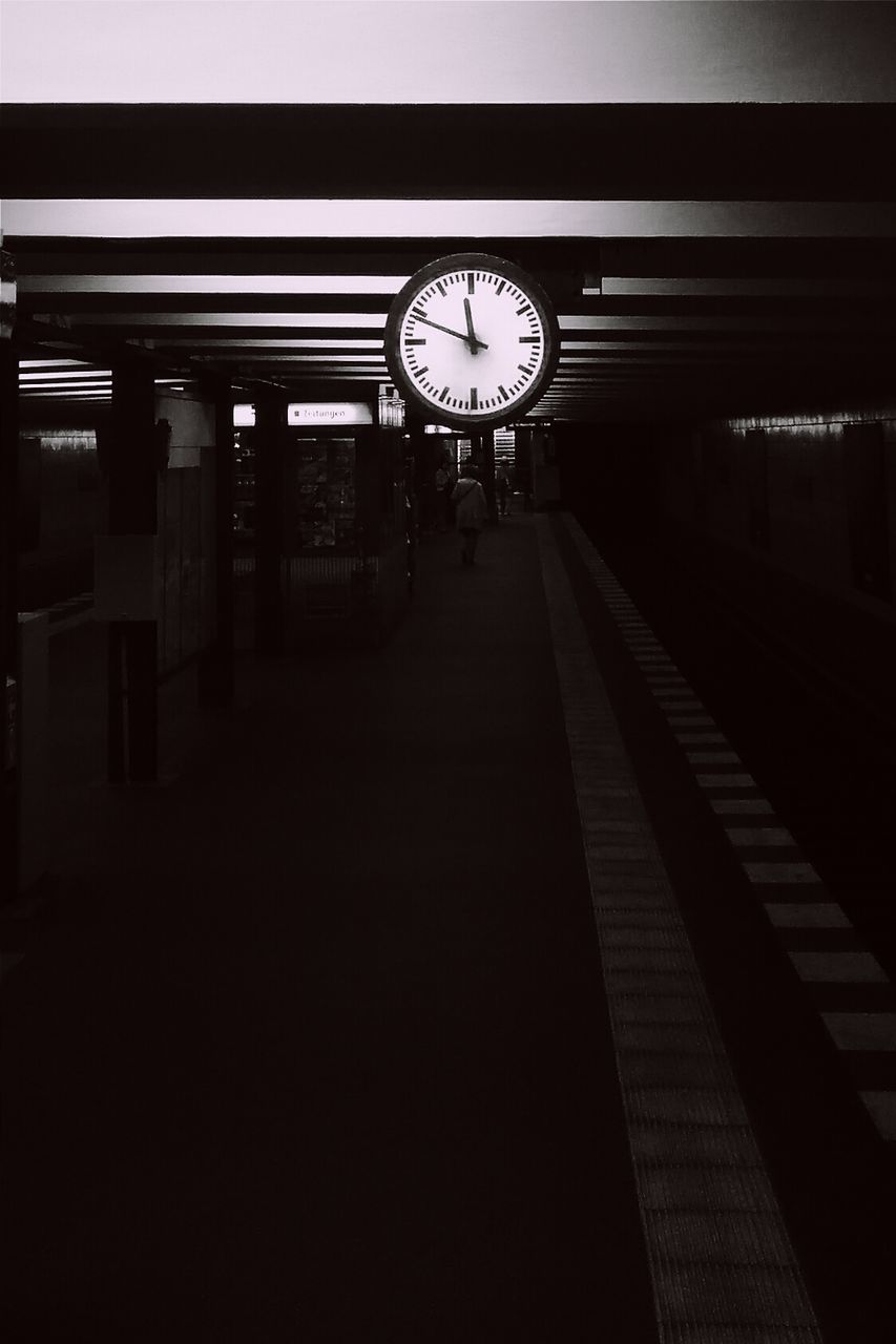 Clock hanging from ceiling in tunnel