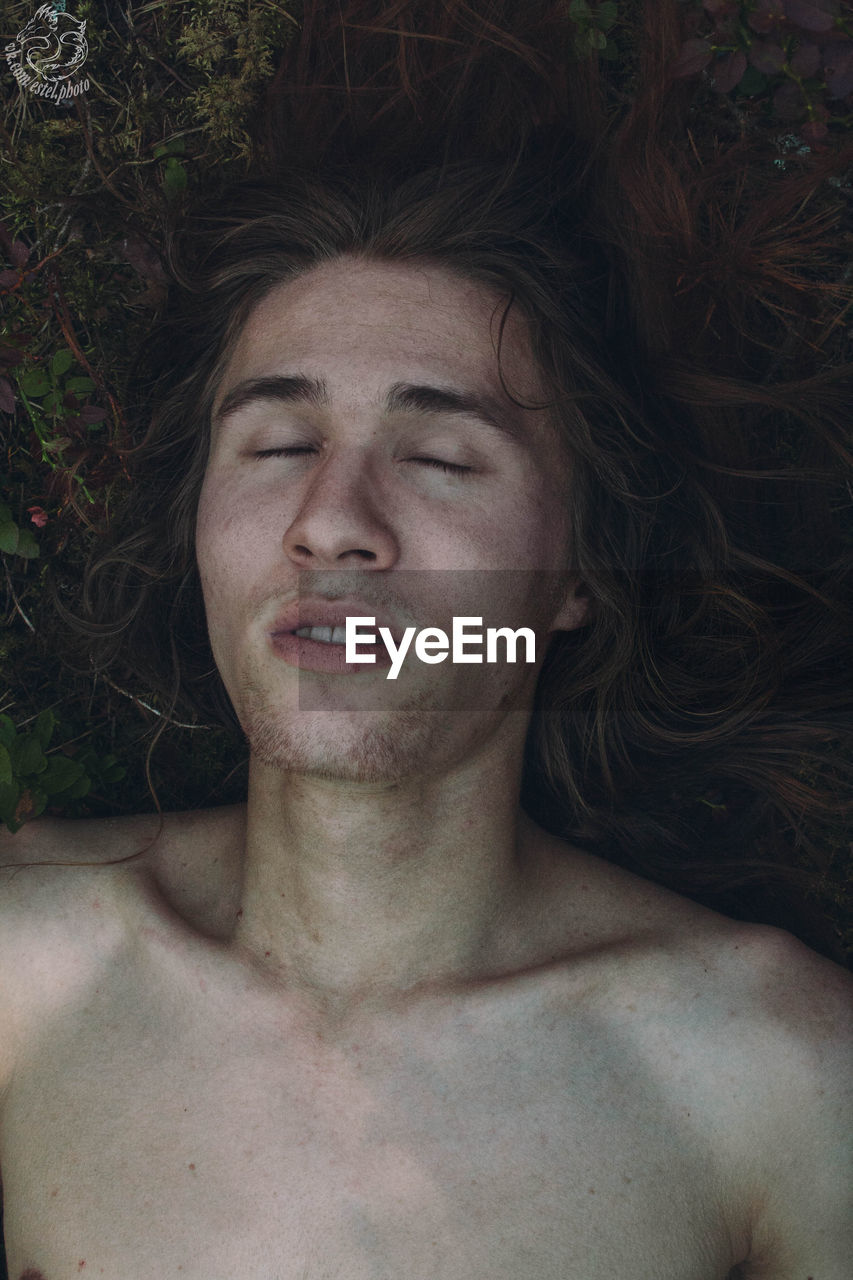 CLOSE-UP PORTRAIT OF YOUNG MAN LYING DOWN