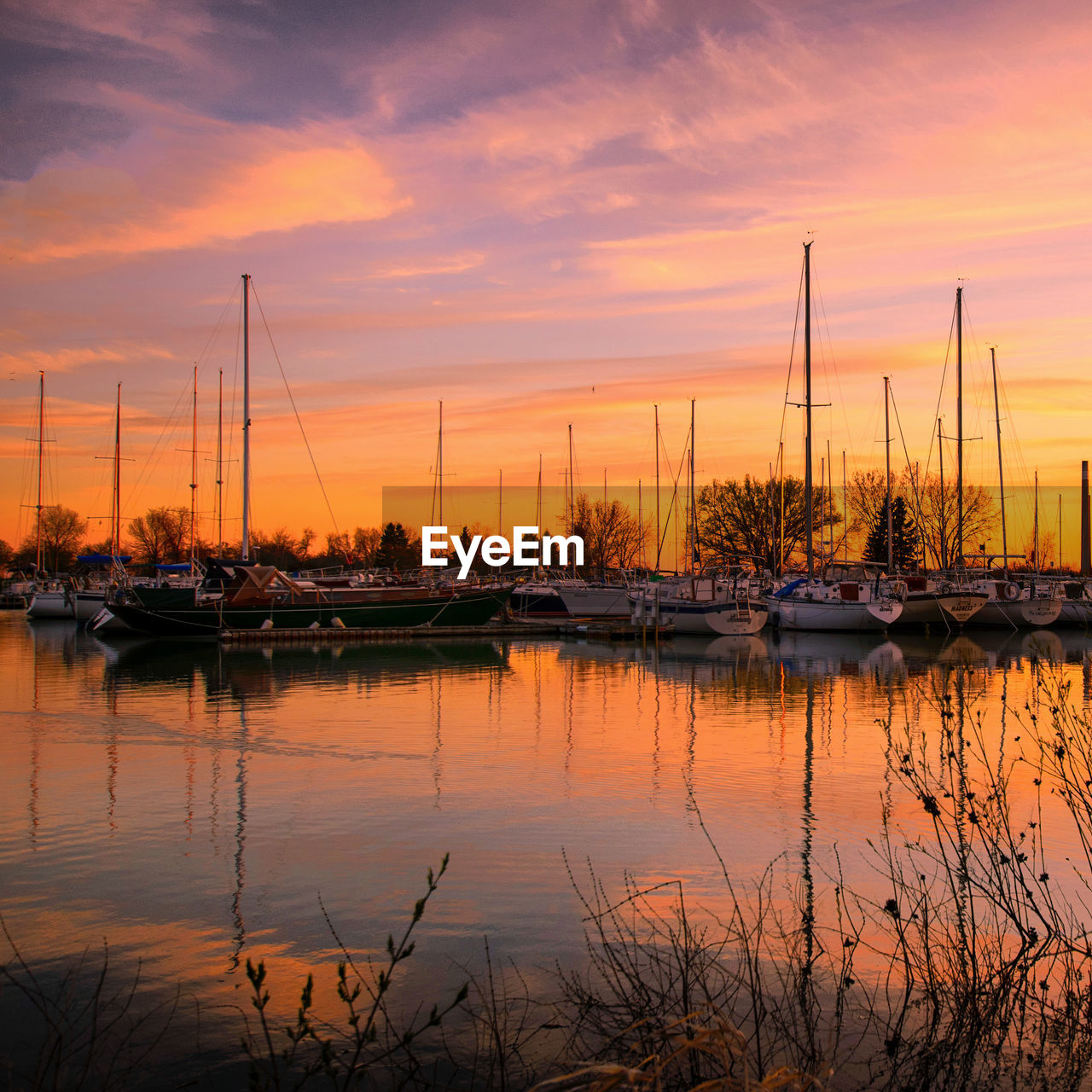 water, sky, nautical vessel, sunset, reflection, transportation, mode of transportation, evening, sailboat, dusk, beauty in nature, ship, nature, cloud, dock, sea, tranquility, marina, no people, harbor, moored, scenics - nature, pole, mast, boat, travel destinations, vehicle, travel, tranquil scene, orange color, sun, idyllic, outdoors, landscape, twilight, architecture, environment, watercraft, dramatic sky, yacht, beach, afterglow, vacation, holiday, silhouette, plant, trip, tourism, sailing