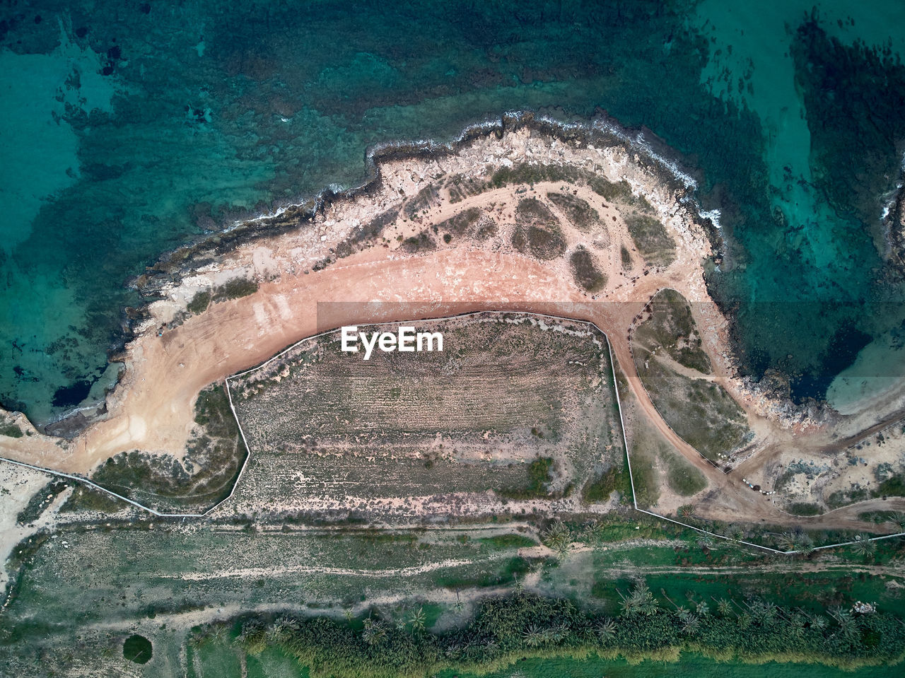 Aerial view of land by sea