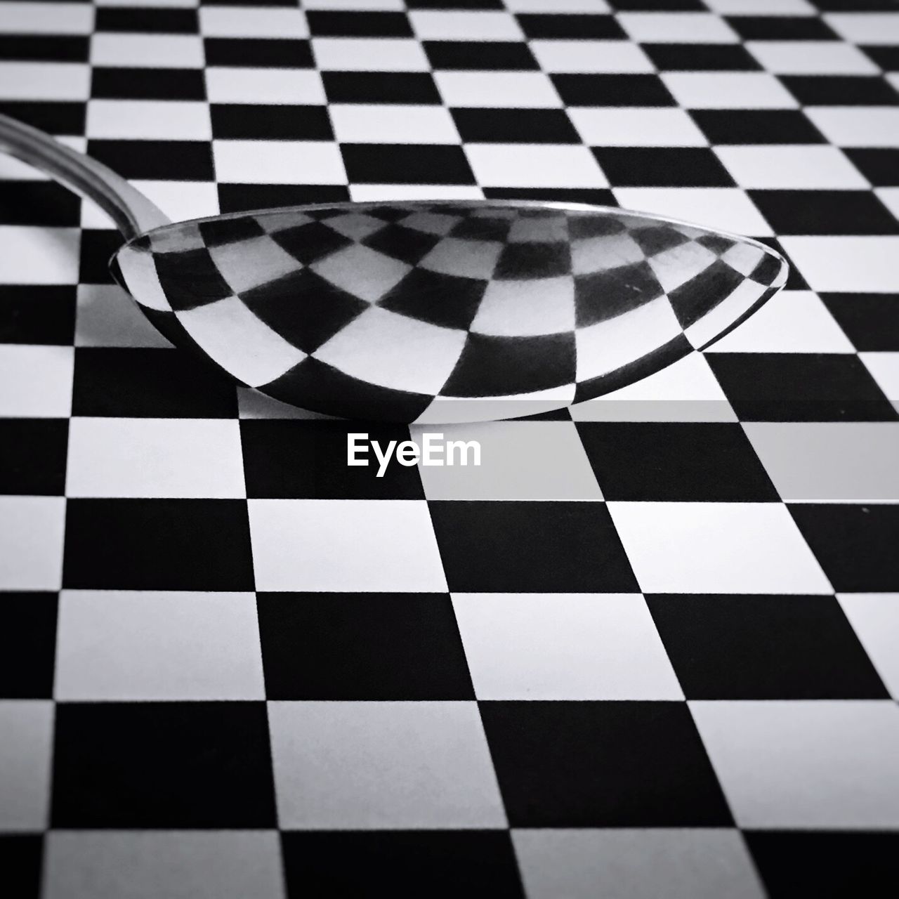 High angle view of spoon on checkerboard