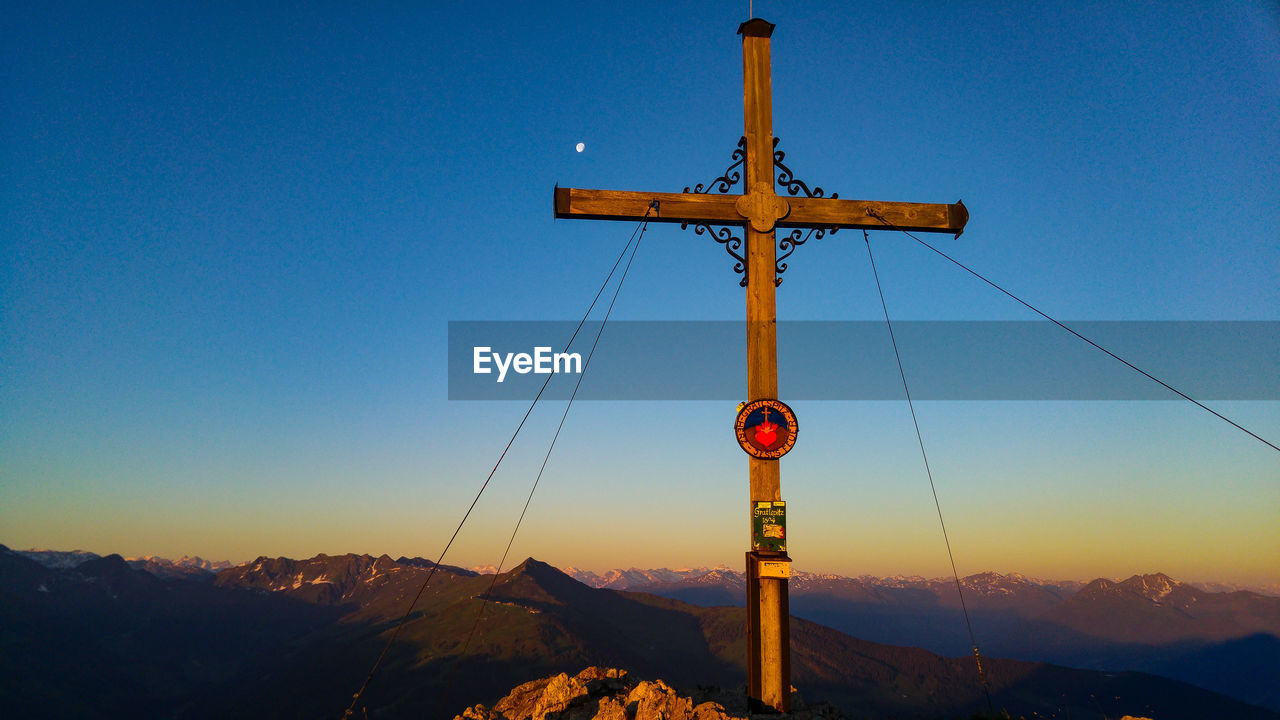 CROSS ON MOUNTAIN AGAINST CLEAR BLUE SKY