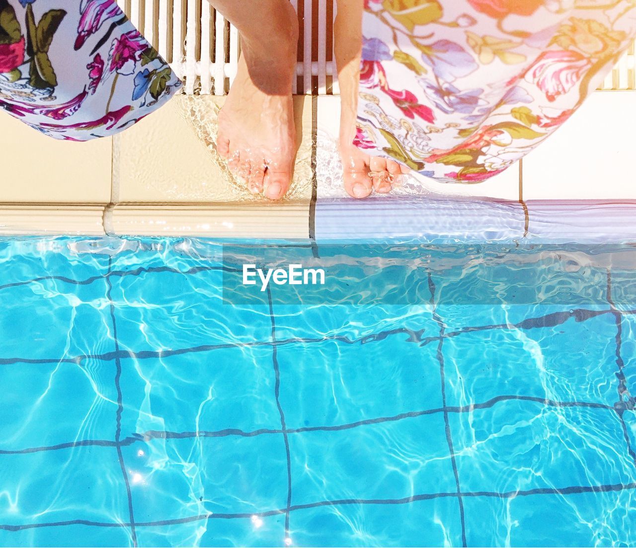Close-up of bare feet by swimming pool