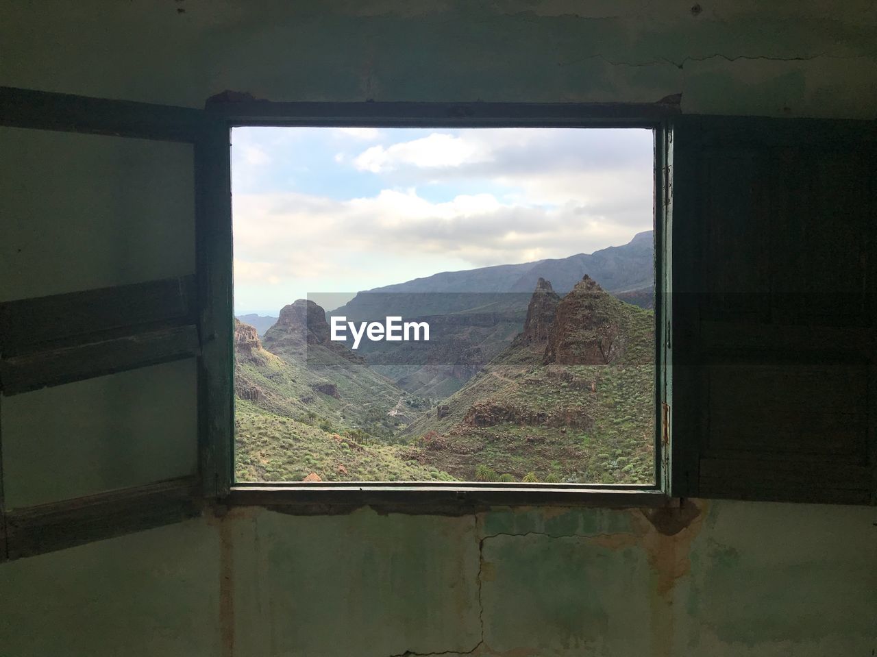 SCENIC VIEW OF MOUNTAINS SEEN THROUGH WINDOW OF SKY