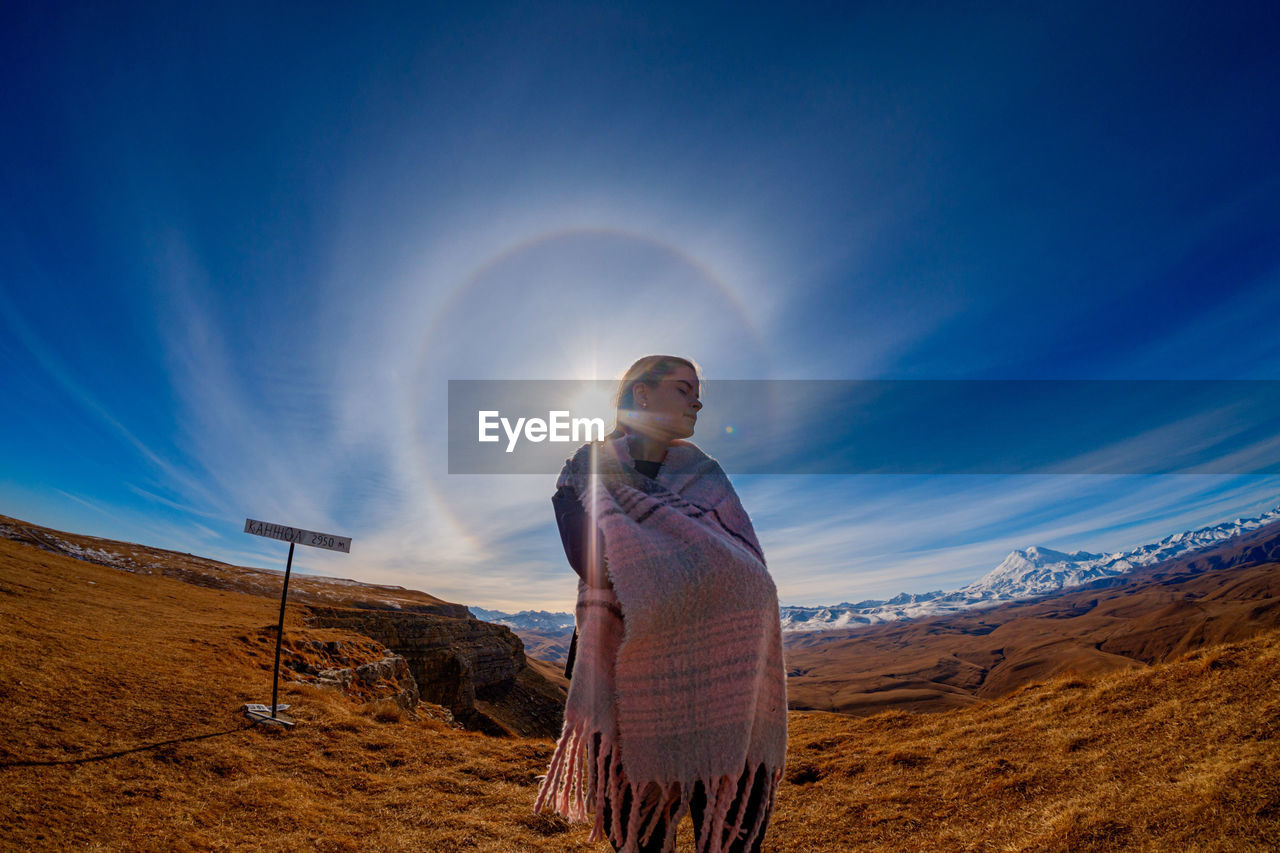 Young man standing on land against sky