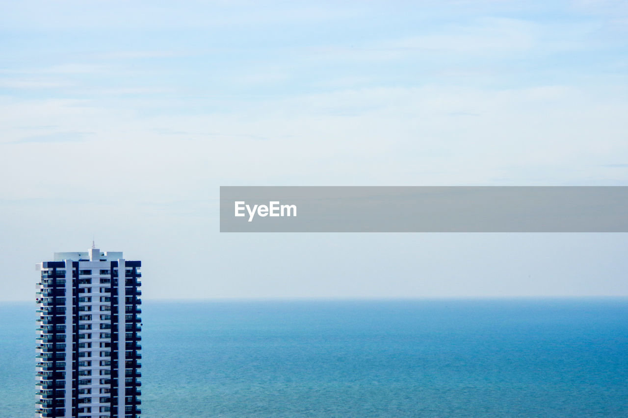 Scenic view of sea by buildings against sky