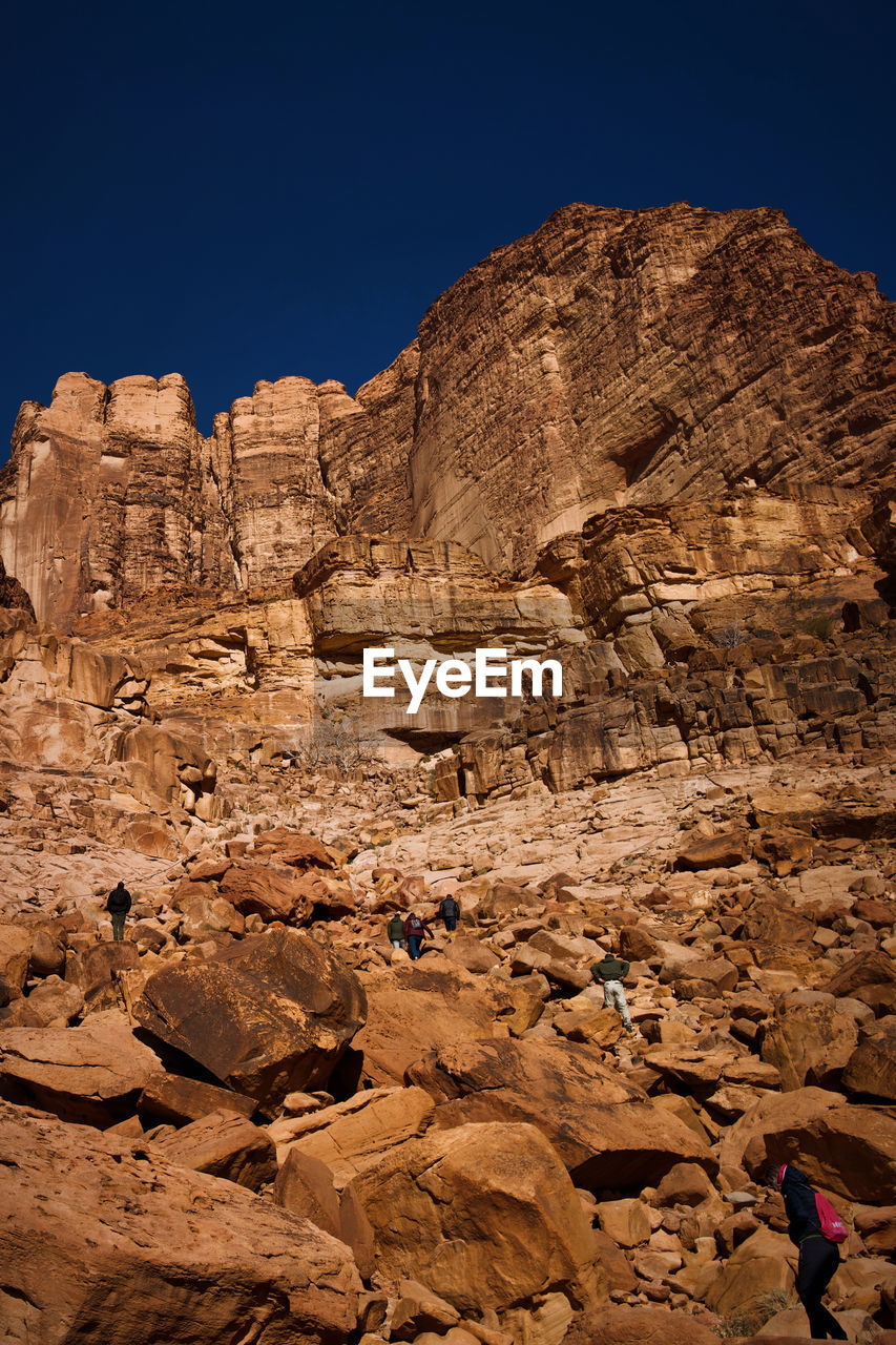 rock, rock formation, nature, sky, wadi, scenics - nature, travel destinations, environment, land, desert, landscape, travel, beauty in nature, valley, geology, arch, clear sky, non-urban scene, mountain, natural environment, terrain, formation, outdoors, blue, climate, cliff, arid climate, no people, ancient history, physical geography, tourism, extreme terrain, plateau, tranquility, day, leisure activity, sunlight