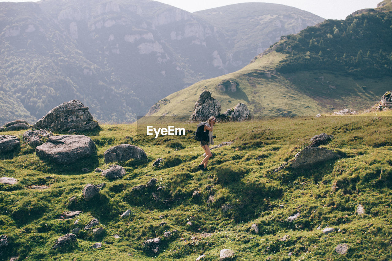 Hiker with camera walking on mountain