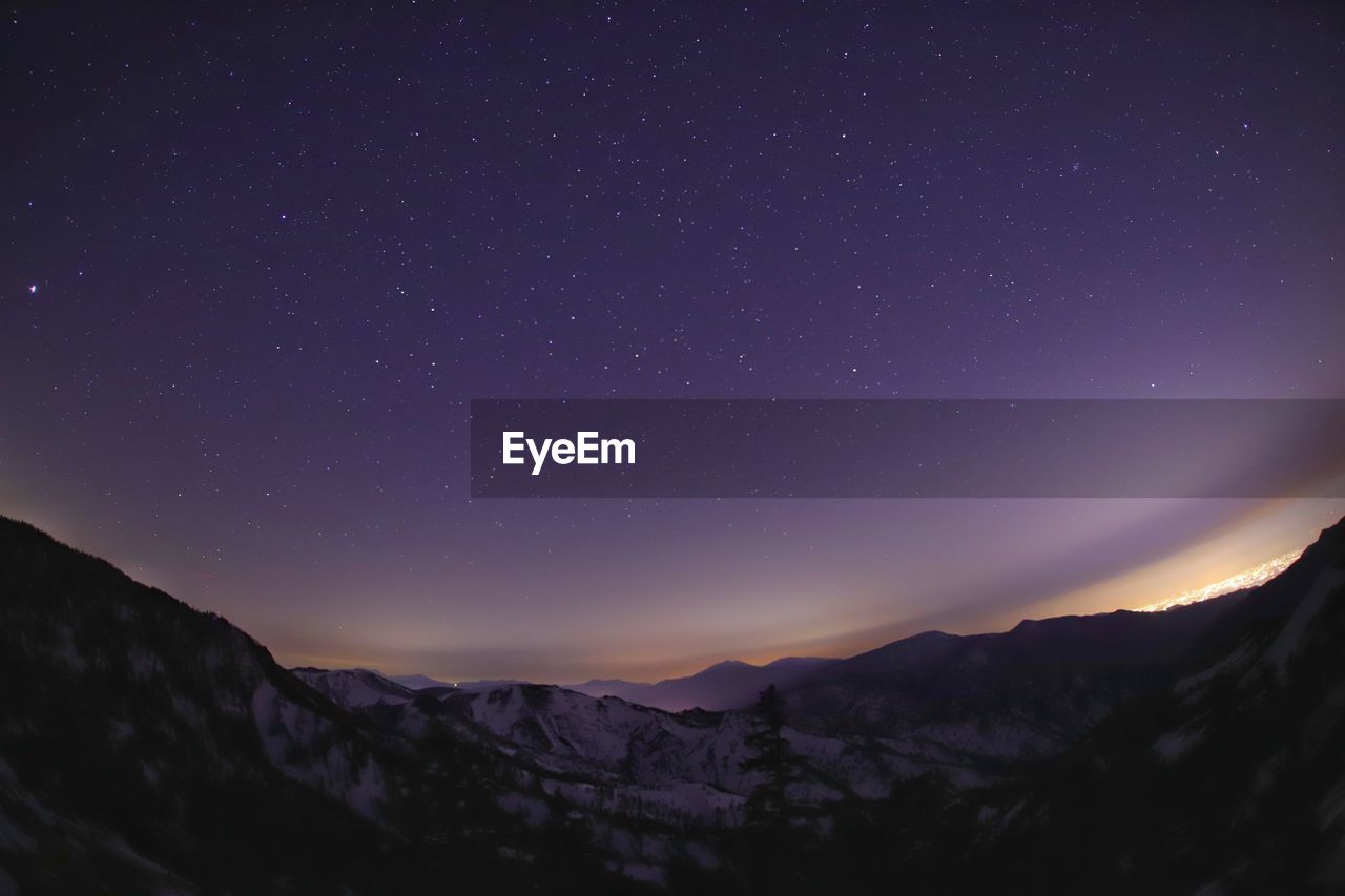 Scenic view of mountains against sky at night