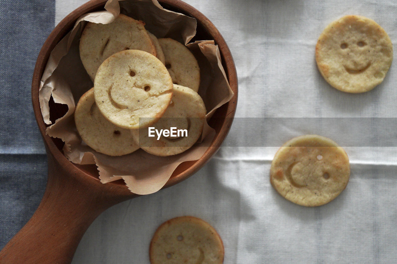 There are some lovely and delicious smiley face potato cakes in the wooden bowl