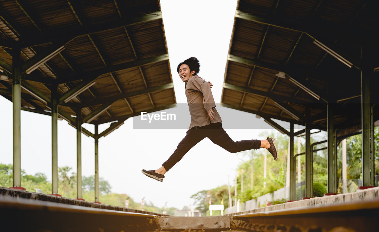 Man jumping on railway, image for travel and lifestyle concept