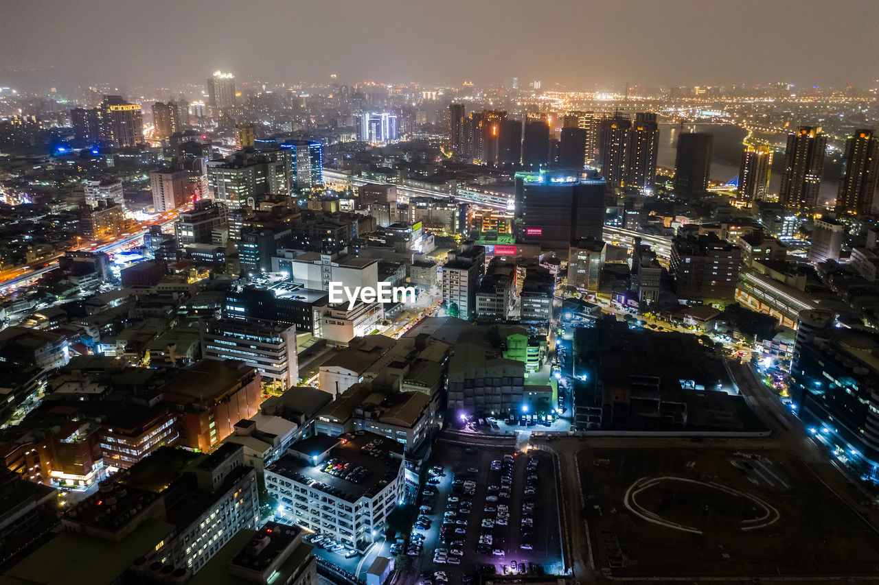 HIGH ANGLE VIEW OF ILLUMINATED CITY BUILDINGS