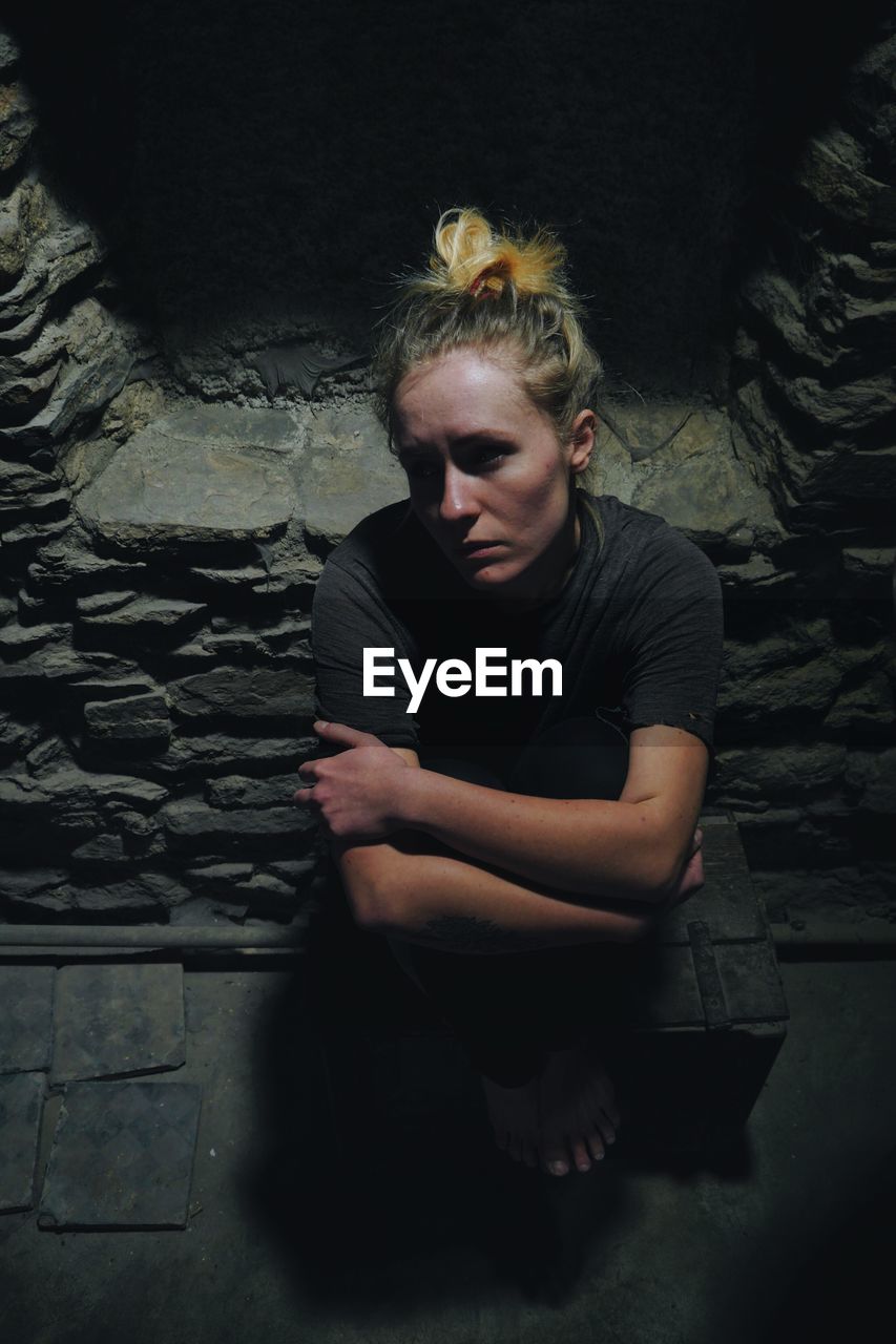 Portrait of a depressed woman in basement