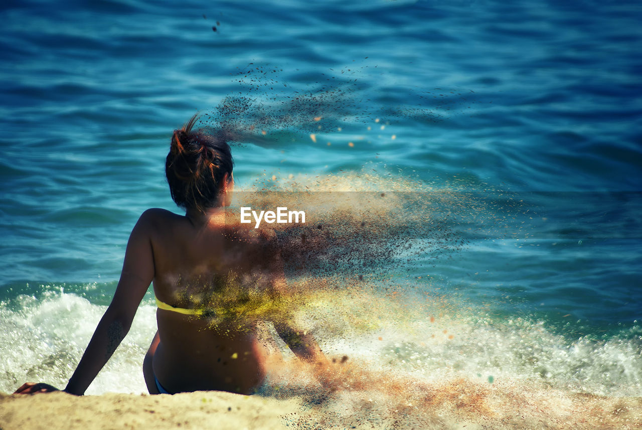 Digital composite image of woman sitting at beach