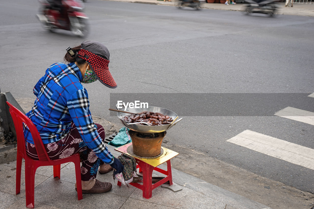 MAN HOLDING UMBRELLA ON ROAD