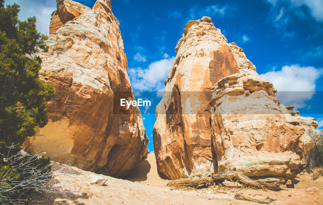 low angle view of rock formations against sky