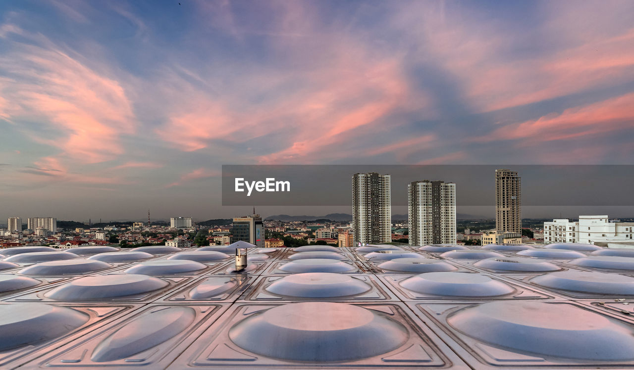 Modern buildings in city during sunset