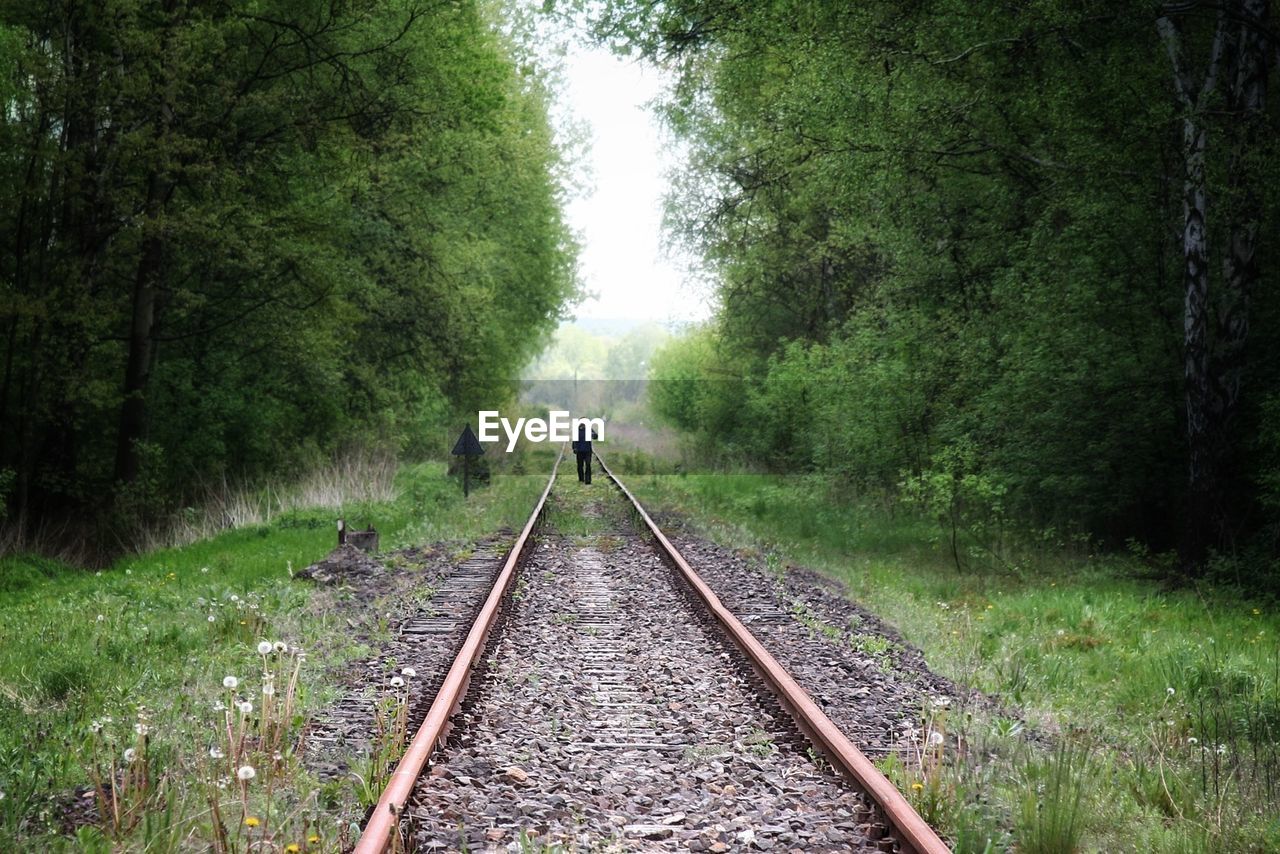 Mid distance view of person walking on railroad tracks