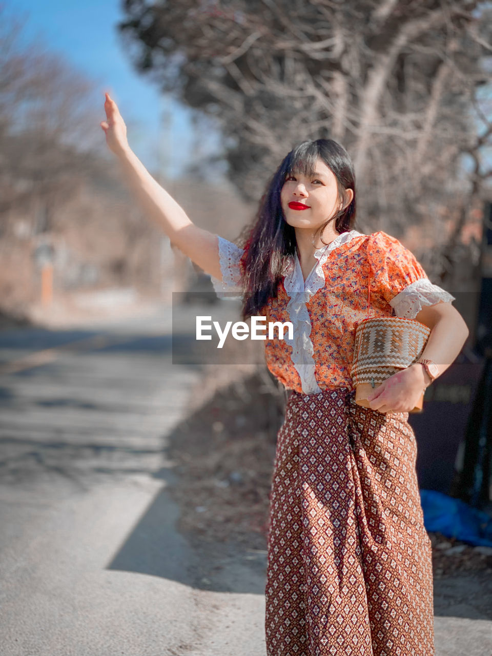 Young woman standing with arms raised