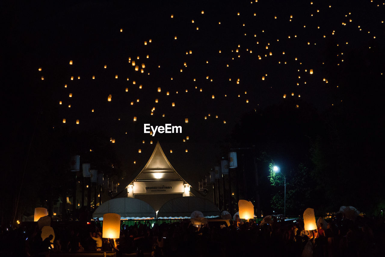 ILLUMINATED LIGHTS IN CITY AGAINST SKY