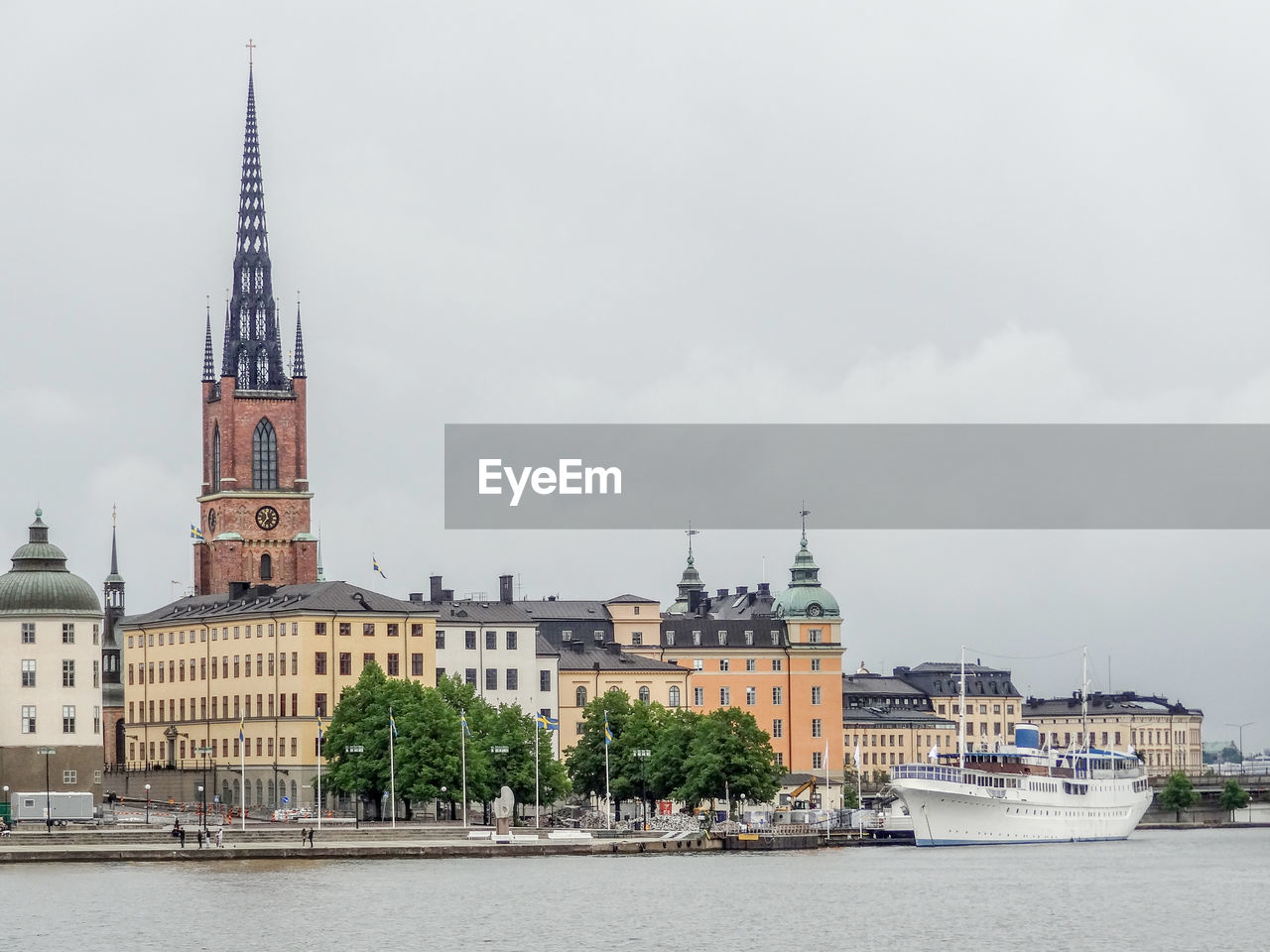 PANORAMIC VIEW OF BUILDINGS BY RIVER AGAINST SKY IN CITY