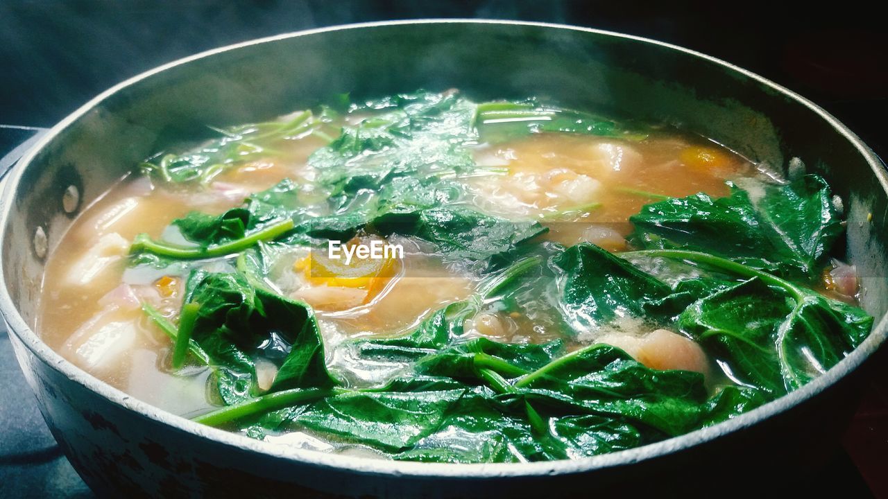 Close-up of meat and vegetable being cooked in pan on stove