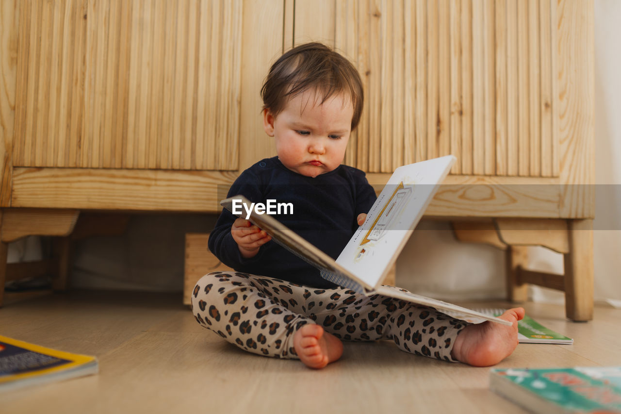 Toddler girl reading book