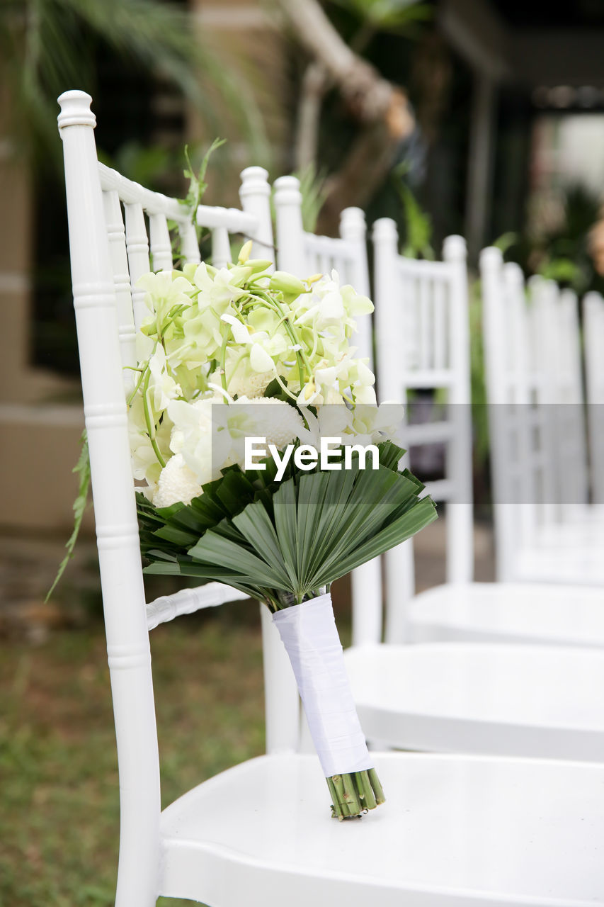 Close-up of white flower bouquet on chair