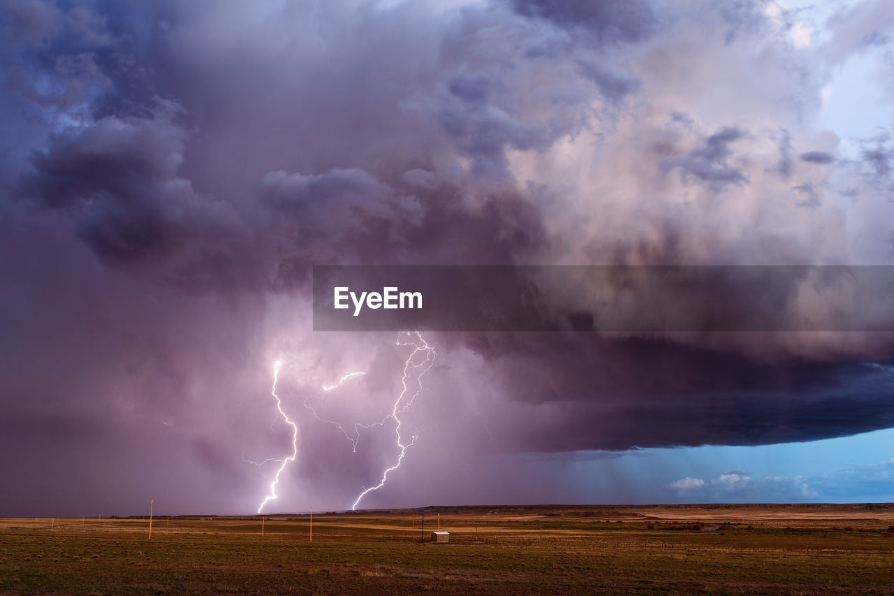 View of lightning over landscape against storm clouds