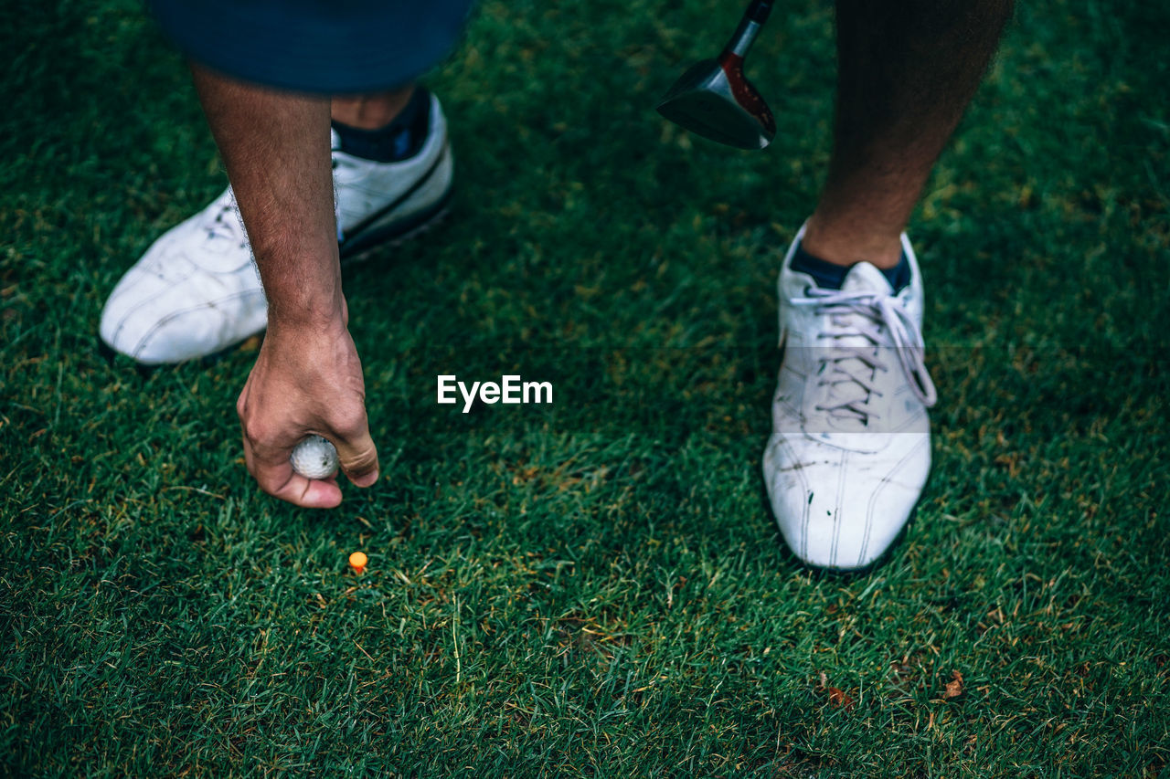 Low section of man playing golf on grass