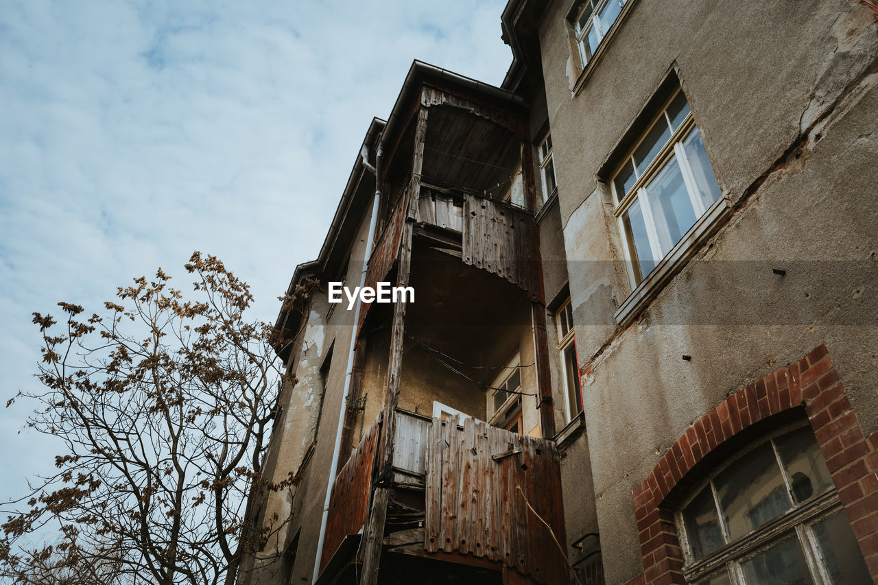 Low angle view of old abandoned building against sky