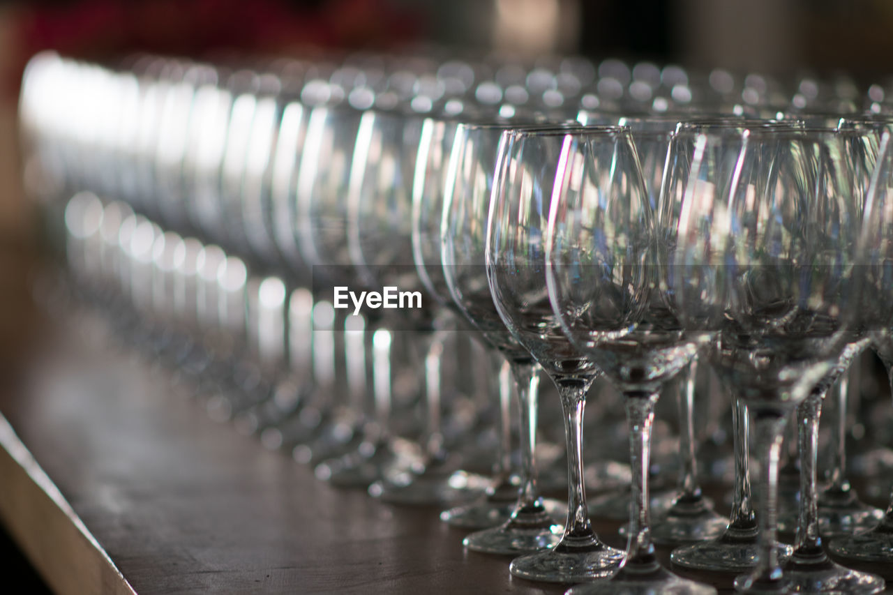 Close-up of wineglasses in row on table