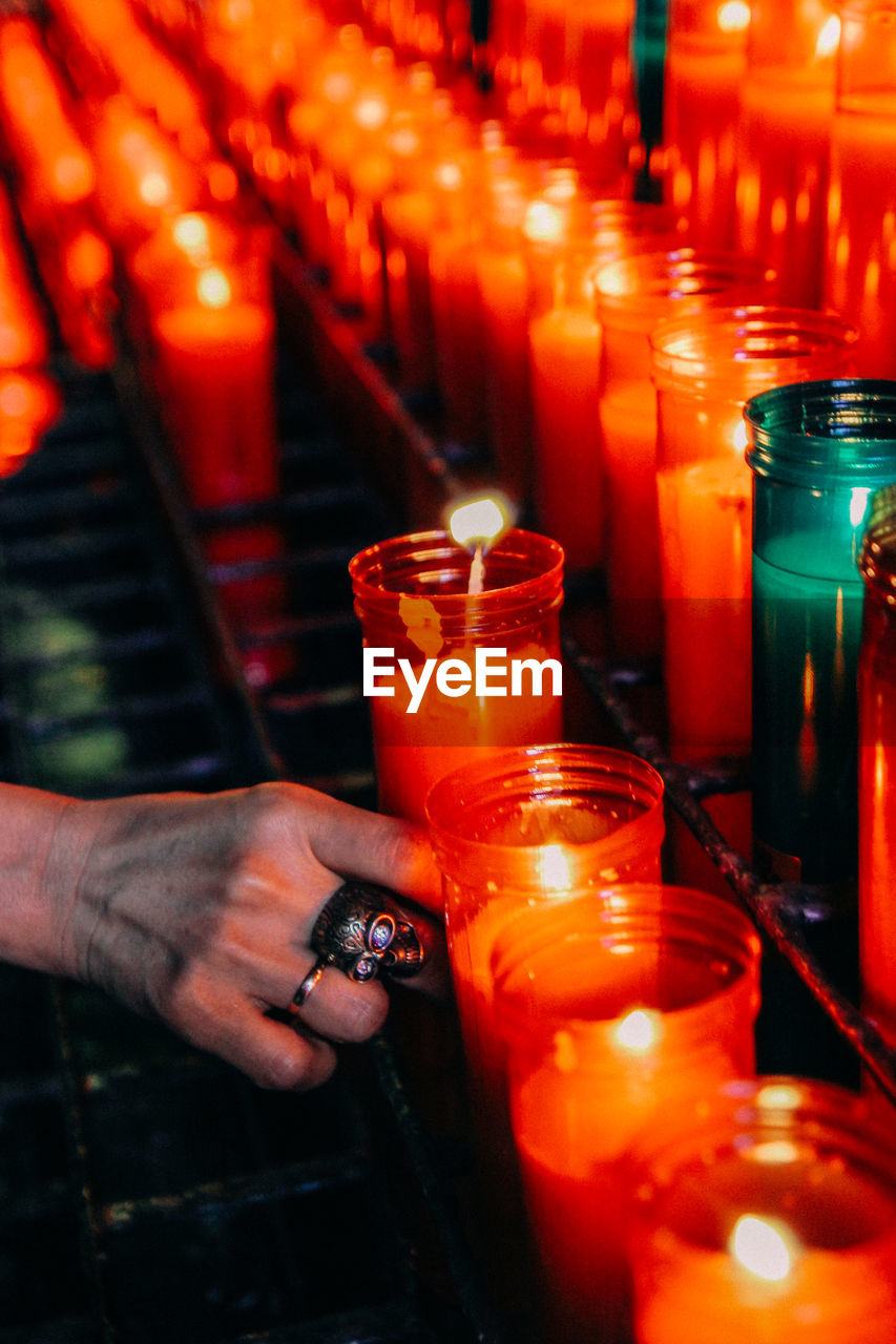 Close-up of hand holding lit candle