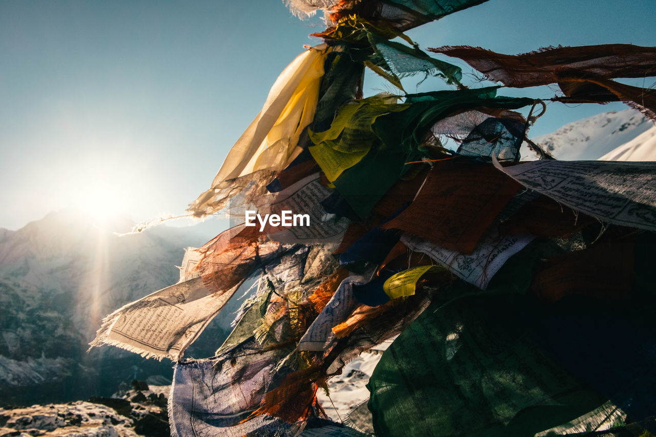 Close-up of prayer flags on mountain during sunny day