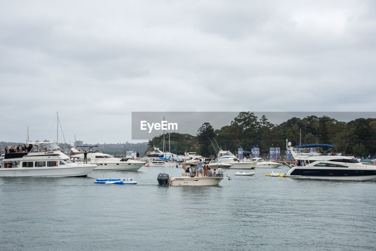 BOATS MOORED IN SEA AGAINST SKY