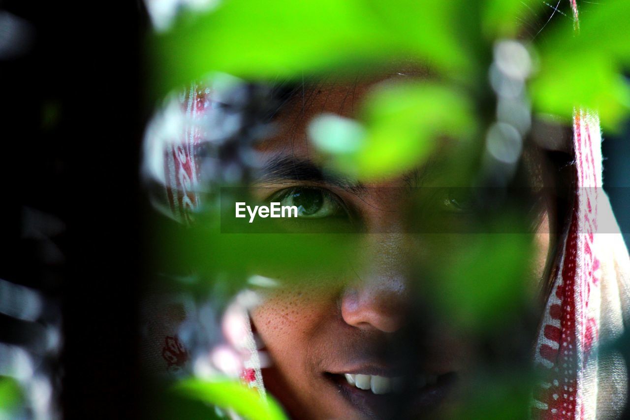 Close-up of woman seen through plant