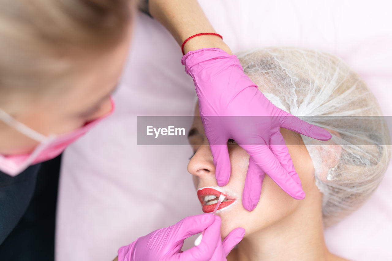 Beautician applying make-up to woman