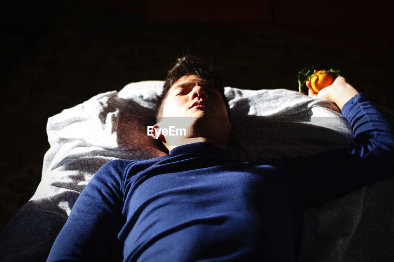 High angle view of man sleeping on bed