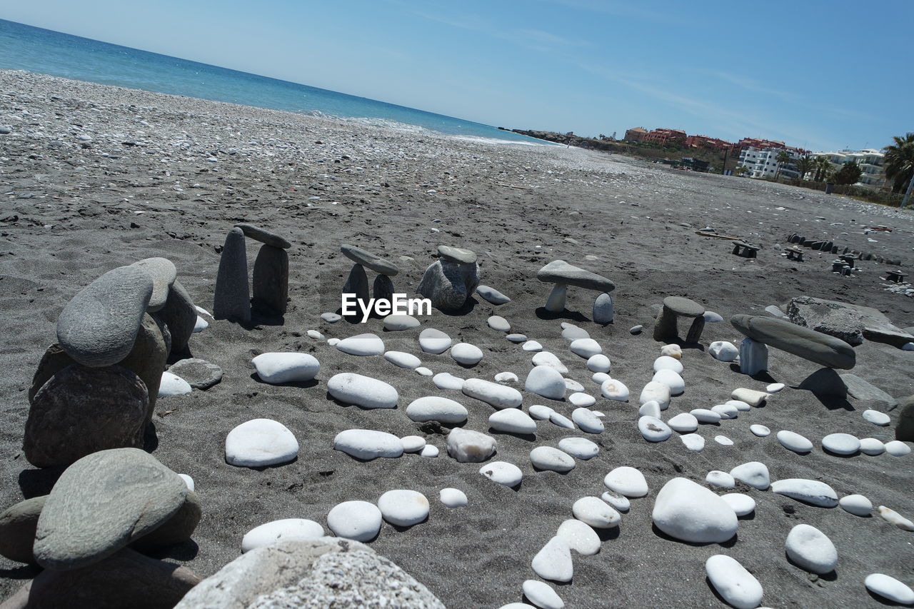 PEBBLES ON BEACH AGAINST SKY